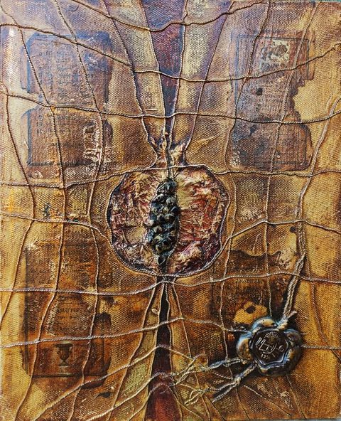 365 Grains: an open pomegranate with dark glossy seeds at the centre of a canvas wrapped in cords, faded Armenian book pages around it and a wax seal on knotted cords at the lower right