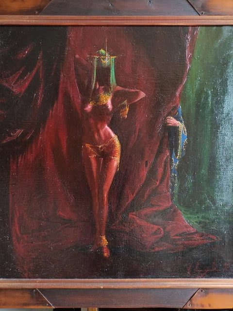 Salome: a dancer stepping out between deep red curtains, her face hidden behind a hanging green-and-gold headdress, wearing gold ornaments; at the right a ringed hand in a blue embroidered sleeve holds the curtain aside