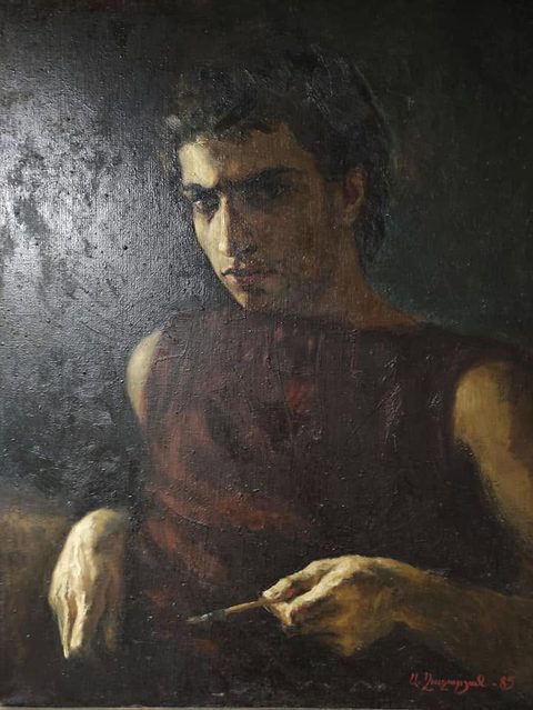 Self-Portrait, 1985: a young dark-haired man in a sleeveless red-brown shirt, half-turned against a dark wall, light falling across half his face, a brush in one hand
