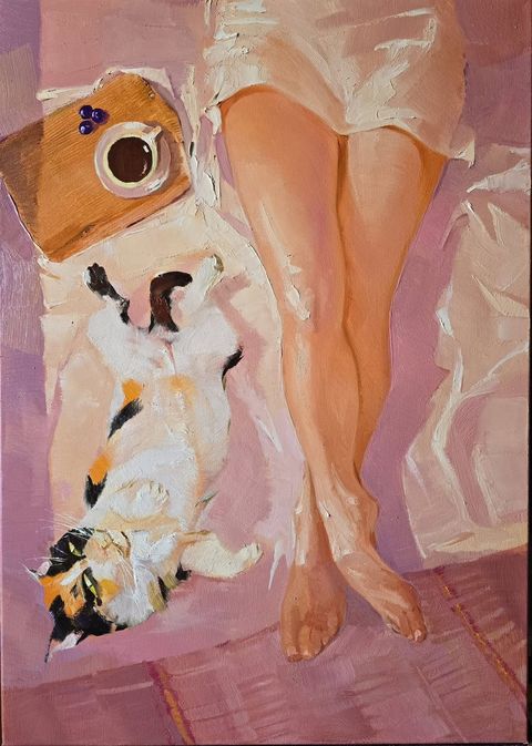 Sunrise V: bare crossed legs on a pink sheet beside a calico cat lying on its back, a coffee cup on a wooden board